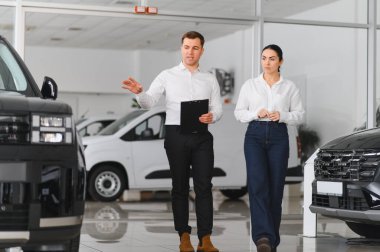 Araba Satış Müdürü, Kafkasyalı Kadın Alıcıya Otomobil Galerisinde Otomobil Gösteriyor. Araç Konsepti Alınıyor