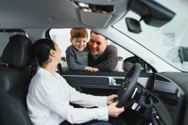 Mutlu bir aile araba galerisinden yeni bir araba alıyor..