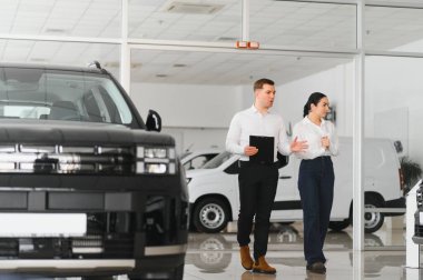 Araba Satış Müdürü, Kafkasyalı Kadın Alıcıya Otomobil Galerisinde Otomobil Gösteriyor. Araç Konsepti Alınıyor