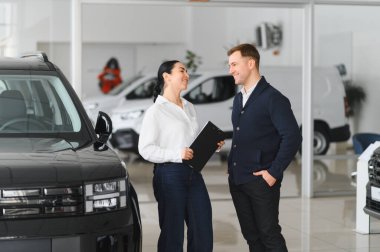 Yetişkin erkek müşteri müşteri alıcısı satış tabelalarına danışıyor araba galerisi araç galerisi galerisi araba galerisinde yeni otomobil almak istiyor. Satış konsepti