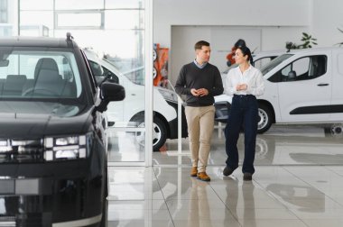 Araba galerisinde yeni bir araba seçen güzel bir çiftin portresi..