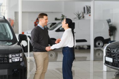 Araba galerisinde yeni bir araba seçen güzel bir çiftin portresi..