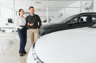 Araba galerisinde yeni bir araba seçen güzel bir çiftin portresi..