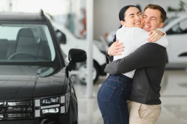 Araba galerisindeki güzel genç çift yeni bir araba aldıkları için dışarı çıktılar..