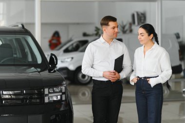 Araba Satış Müdürü, Kafkasyalı Kadın Alıcıya Otomobil Galerisinde Otomobil Gösteriyor. Araç Konsepti Alınıyor