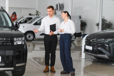 Araba Satış Müdürü, Kafkasyalı Kadın Alıcıya Otomobil Galerisinde Otomobil Gösteriyor. Araç Konsepti Alınıyor