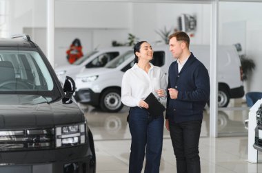 Yetişkin erkek müşteri müşteri alıcısı satış tabelalarına danışıyor araba galerisi araç galerisi galerisi araba galerisinde yeni otomobil almak istiyor. Satış konsepti