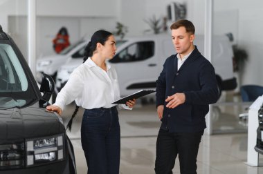 Yetişkin erkek müşteri müşteri alıcısı satış tabelalarına danışıyor araba galerisi araç galerisi galerisi araba galerisinde yeni otomobil almak istiyor. Satış konsepti