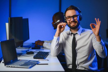 Çağrı merkezinde genç erkek teknik destek memuru.