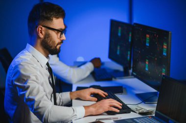 Bilgisayar ekranına bakan kripto tüccar yatırımcısı analizcisi bilgisayar ekranındaki finansal grafik verilerini analiz ediyor, online borsa ticaret yatırımları hakkında düşünüyor omuz manzarası üzerinden küresel riskler.