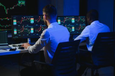 Takım çalışması kavramı. Borsacılardan oluşan bir ekip modern ofiste birçok ekran ekranı ile çalışır..