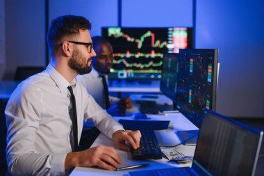 Takım çalışması kavramı. Borsacılardan oluşan bir ekip modern ofiste birçok ekran ekranı ile çalışır..