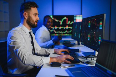 Takım çalışması kavramı. Borsacılardan oluşan bir ekip modern ofiste birçok ekran ekranı ile çalışır..