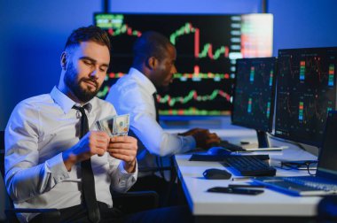 Borsada dolarları elinde tutuyor. Yatırımcı borsada büyük paralar kazandıktan sonra para sayıyor..