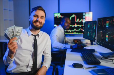 Takım çalışması kavramı. Borsacılardan oluşan bir ekip modern ofiste birçok ekran ekranı ile çalışır..