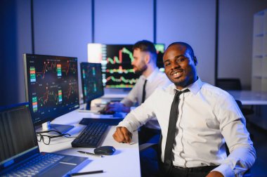 Takım çalışması kavramı. Borsacılardan oluşan bir ekip modern ofiste birçok ekran ekranı ile çalışır..