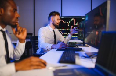 Önx ticaret grafikleri ve grafikleri ile bilgisayar ekranında çalışan tüccar takımı.