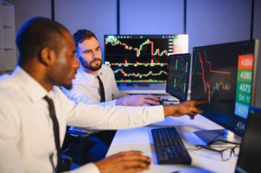 Takım çalışması kavramı. Borsacılardan oluşan bir ekip modern ofiste birçok ekran ekranı ile çalışır..