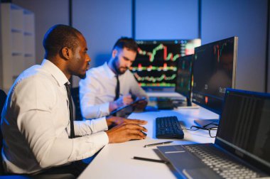 Takım çalışması kavramı. Borsacılardan oluşan bir ekip modern ofiste birçok ekran ekranı ile çalışır..