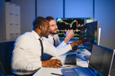 Takım çalışması kavramı. Borsacılardan oluşan bir ekip modern ofiste birçok ekran ekranı ile çalışır..