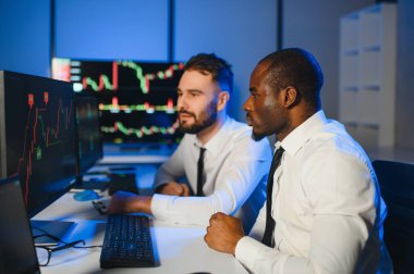 Takım çalışması kavramı. Borsacılardan oluşan bir ekip modern ofiste birçok ekran ekranı ile çalışır..