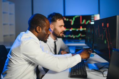 Bu başarıdır. Ofiste kazanan anlaşmayı kutlayan iki mutlu tüccar ya da mali analist var..