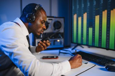 Gizli ajan kayıt cihazını dinliyormuş. Memur kulaklıkla dinleme yapıyor..