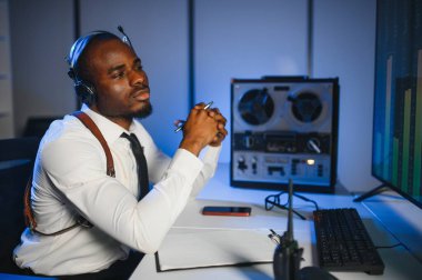 Gizli ajan kayıt cihazını dinliyormuş. Memur kulaklıkla dinleme yapıyor..