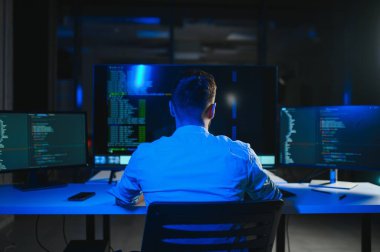 Geceleri ofiste erkek programcının portresi.