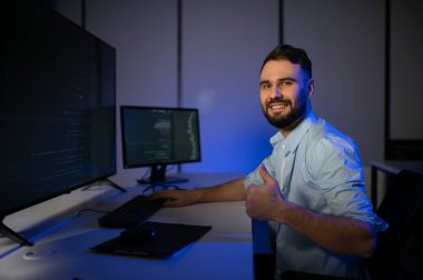 Geceleri ofiste erkek programcının portresi.
