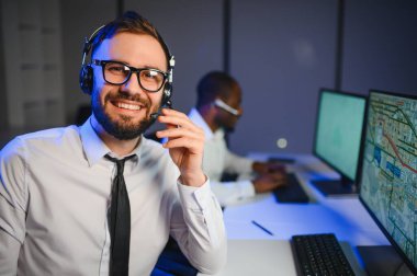 Tamirat merkezi. Seyrüsefer kontrol panosunda otururken mikrofonla çalışan erkeklerin portresi.