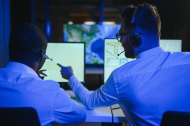 Tamirat merkezi. Seyrüsefer kontrol panosunda otururken mikrofonla çalışan erkeklerin portresi.