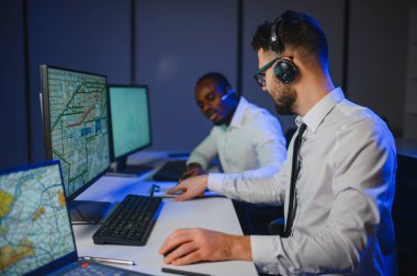 Tamirat merkezi. Seyrüsefer kontrol panosunda otururken mikrofonla çalışan erkeklerin portresi.
