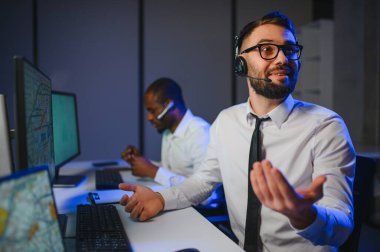 Tamirat merkezi. Seyrüsefer kontrol panosunda otururken mikrofonla çalışan erkeklerin portresi.