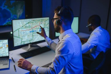 Tamirat merkezi. Seyrüsefer kontrol panosunda otururken mikrofonla çalışan erkeklerin portresi.