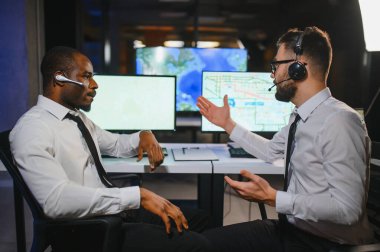 Tamirat merkezi. Seyrüsefer kontrol panosunda otururken mikrofonla çalışan erkeklerin portresi.