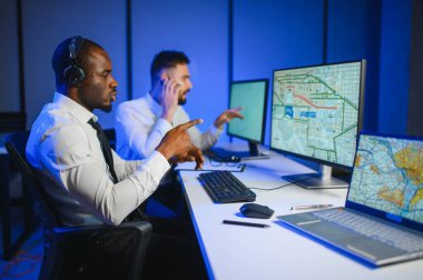 Tamirat merkezi. Seyrüsefer kontrol panosunda otururken mikrofonla çalışan erkeklerin portresi.