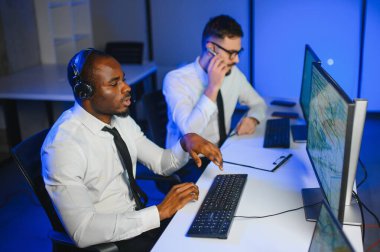 Tamirat merkezi. Seyrüsefer kontrol panosunda otururken mikrofonla çalışan erkeklerin portresi.