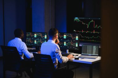 Takım çalışması kavramı. Borsacılardan oluşan bir ekip modern ofiste birçok ekran ekranı ile çalışır..