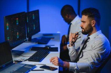 Takım çalışması kavramı. Borsacılardan oluşan bir ekip modern ofiste birçok ekran ekranı ile çalışır..