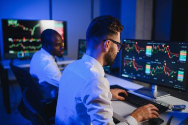 Takım çalışması kavramı. Borsacılardan oluşan bir ekip modern ofiste birçok ekran ekranı ile çalışır..