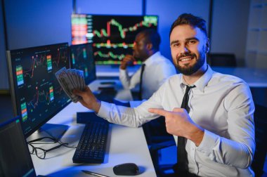 Takım çalışması kavramı. Borsacılardan oluşan bir ekip modern ofiste birçok ekran ekranı ile çalışır..