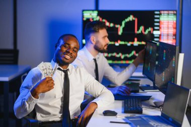 Takım çalışması kavramı. Borsacılardan oluşan bir ekip modern ofiste birçok ekran ekranı ile çalışır..