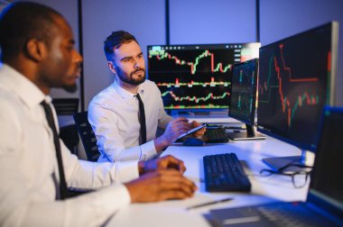 Takım çalışması kavramı. Borsacılardan oluşan bir ekip modern ofiste birçok ekran ekranı ile çalışır..