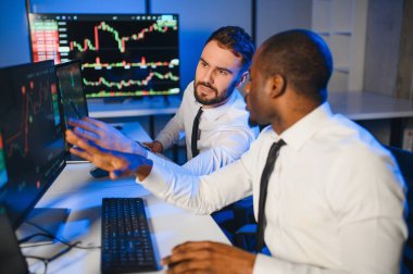 Takım çalışması kavramı. Borsacılardan oluşan bir ekip modern ofiste birçok ekran ekranı ile çalışır..