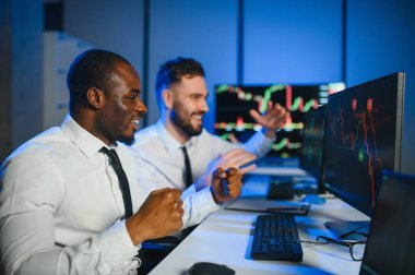 Bu başarıdır. Ofiste kazanan anlaşmayı kutlayan iki mutlu tüccar ya da mali analist var..