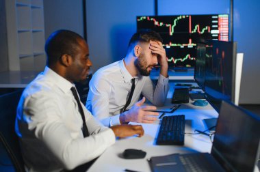 Takım çalışması kavramı. Borsacılardan oluşan bir ekip modern ofiste birçok ekran ekranı ile çalışır..