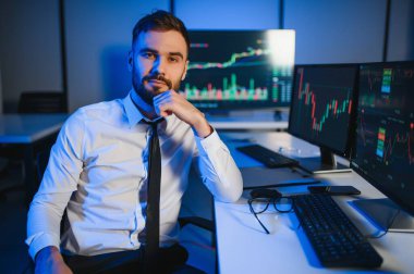 Bilgisayar ekranına bakan kripto tüccar yatırımcısı analizcisi bilgisayar ekranındaki finansal grafik verilerini analiz ediyor, online borsa ticaret yatırımları hakkında düşünüyor omuz manzarası üzerinden küresel riskler.