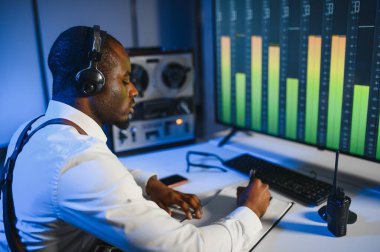 Gizli ajan kayıt cihazını dinliyormuş. Memur kulaklıkla dinleme yapıyor..