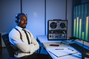 Gizli ajan kayıt cihazını dinliyormuş. Memur kulaklıkla dinleme yapıyor..